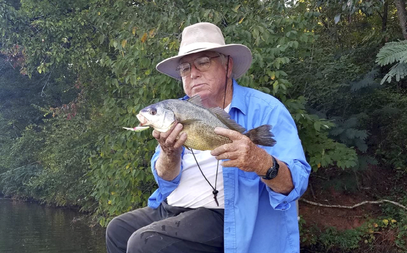 Man holding a fish he caught while fishing in Alabama