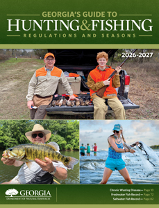 Cover of the 2026–2027 Georgia's Guide to Hunting & Fishing Regulations and Seasons featuring two hunters with harvested game, an angler holding a largemouth bass, and a woman casting a fishing net.