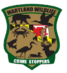 Maryland Wildlife Crime Stoppers logo featuring silhouettes of a bear, crab, deer, duck, and heron over a Maryland flag background with green and brown border.