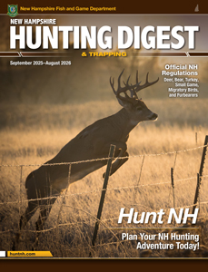 Cover of the 2025–2026 New Hampshire Hunting Digest. A large buck with tall antlers leaps over a barbed wire fence in a golden-brown field during early morning or late afternoon light.
