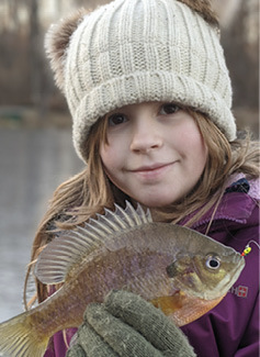 9-year-old Sierra with the bluegill sunfish she caught on a frozen Morris County pond.