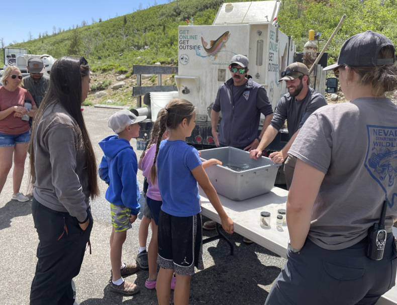 Gallagher Fish Hatchery staff teaching about the life cycle of a trout at the Angel Lake Kids Fishing Derby.