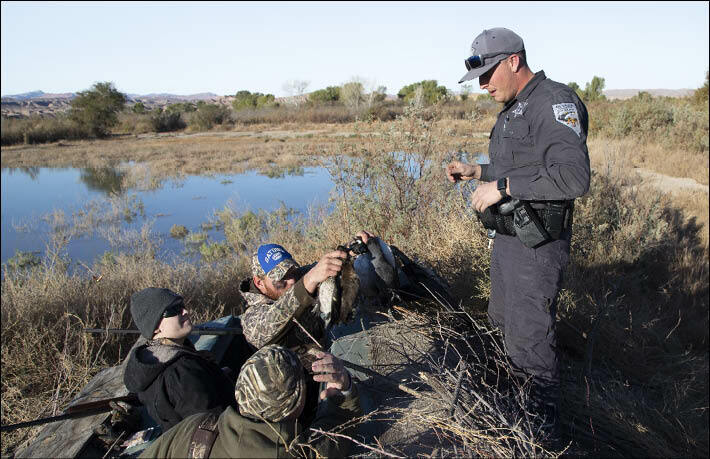 A game warden for the Nevada Department of Wildlife talks with a group of migratory bird hunters