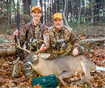 Two hunters with a deer