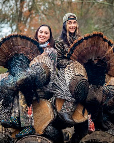 Two turkey hunters with their turkeys