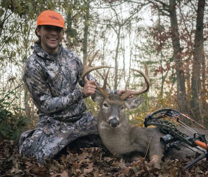 Hunter with a deer he harvested while deer hunting in Rhode Island