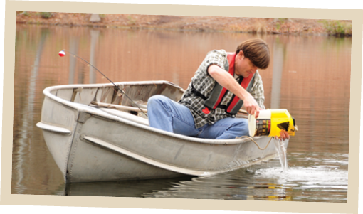 Un hombre en un pequeño bote de aluminio limpia y drena el agua de un contenedor amarillo después de pescar. Lleva puesto un chaleco salvavidas y tiene una caña de pescar a su lado. La imagen promueve prácticas responsables para prevenir la propagación de especies acuáticas invasoras.